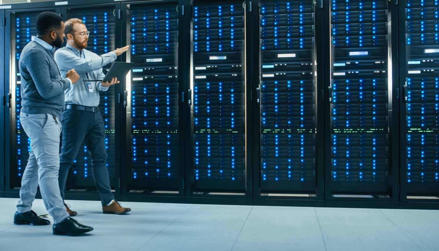 Two individuals walking through a room with computer servers, presumably going over their data retention compliance efforts